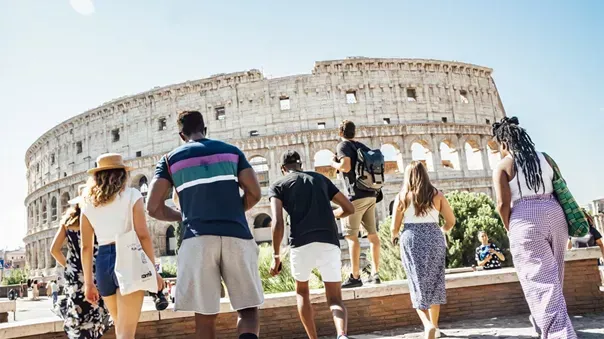 Contiki A group of people are standing in front of the colosseum in rome Barters Travelnet