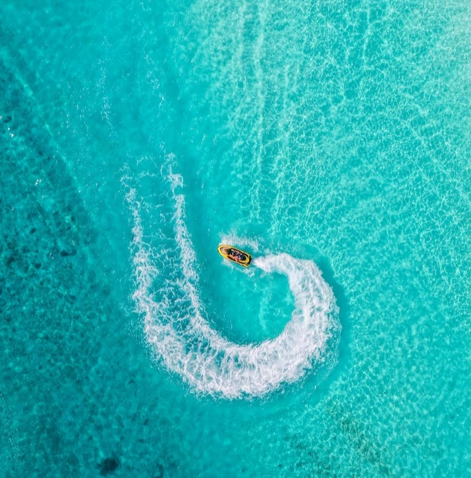 Aerial View of 2 people riding a jet ski on a beautiful turquoise blue ocean in Marbella, Malaga, Spain - Blog Post Barters Travelnet