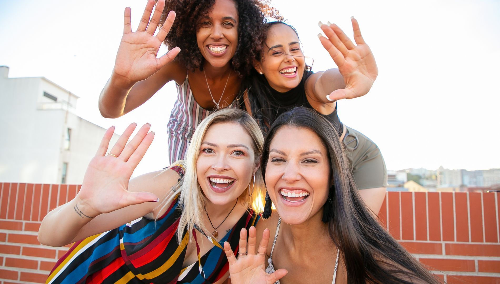 A group of women are waving their hands in the air.