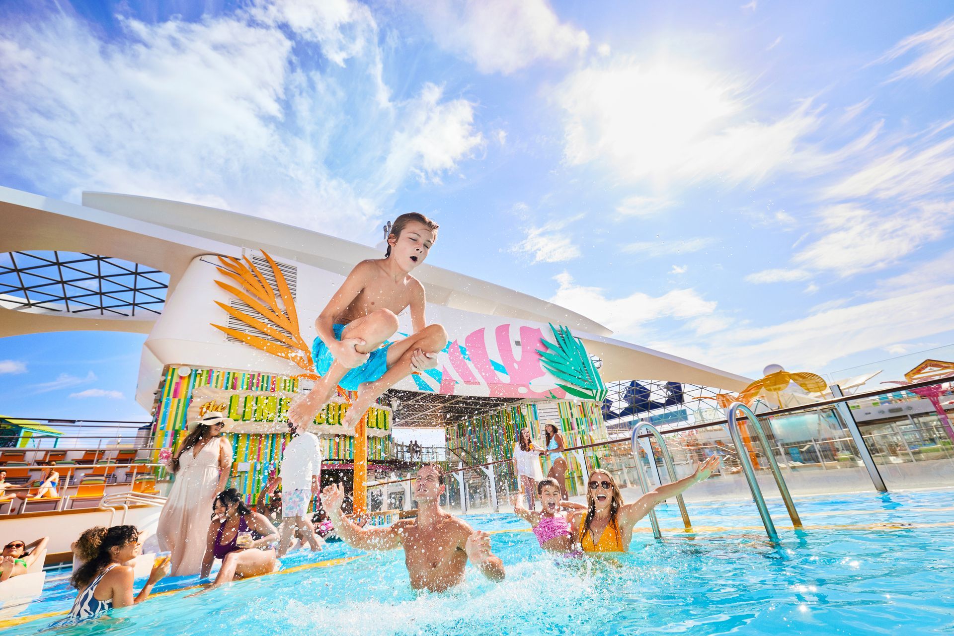 A group of people are jumping into a swimming pool on a cruise ship.