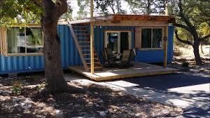 blue shipping container home in the woods