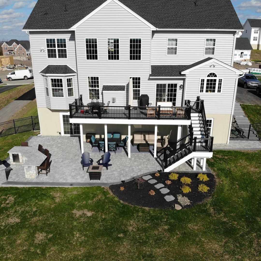 An aerial view of a large white house with a large patio.