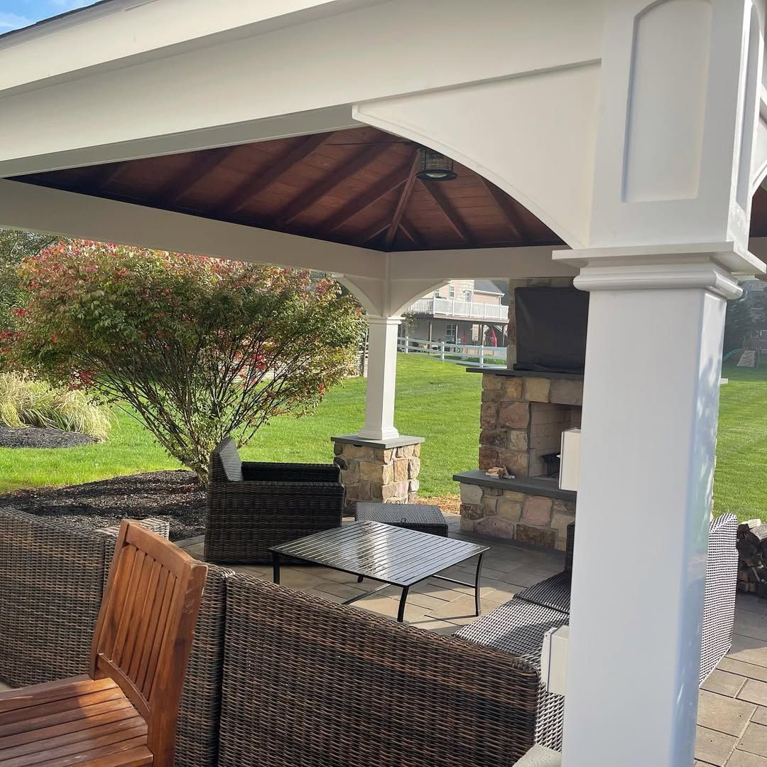 A gazebo with a table and chairs underneath it.