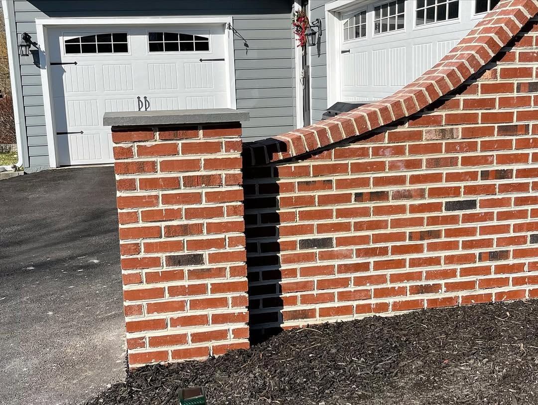 A red brick wall with a white garage door in the background.