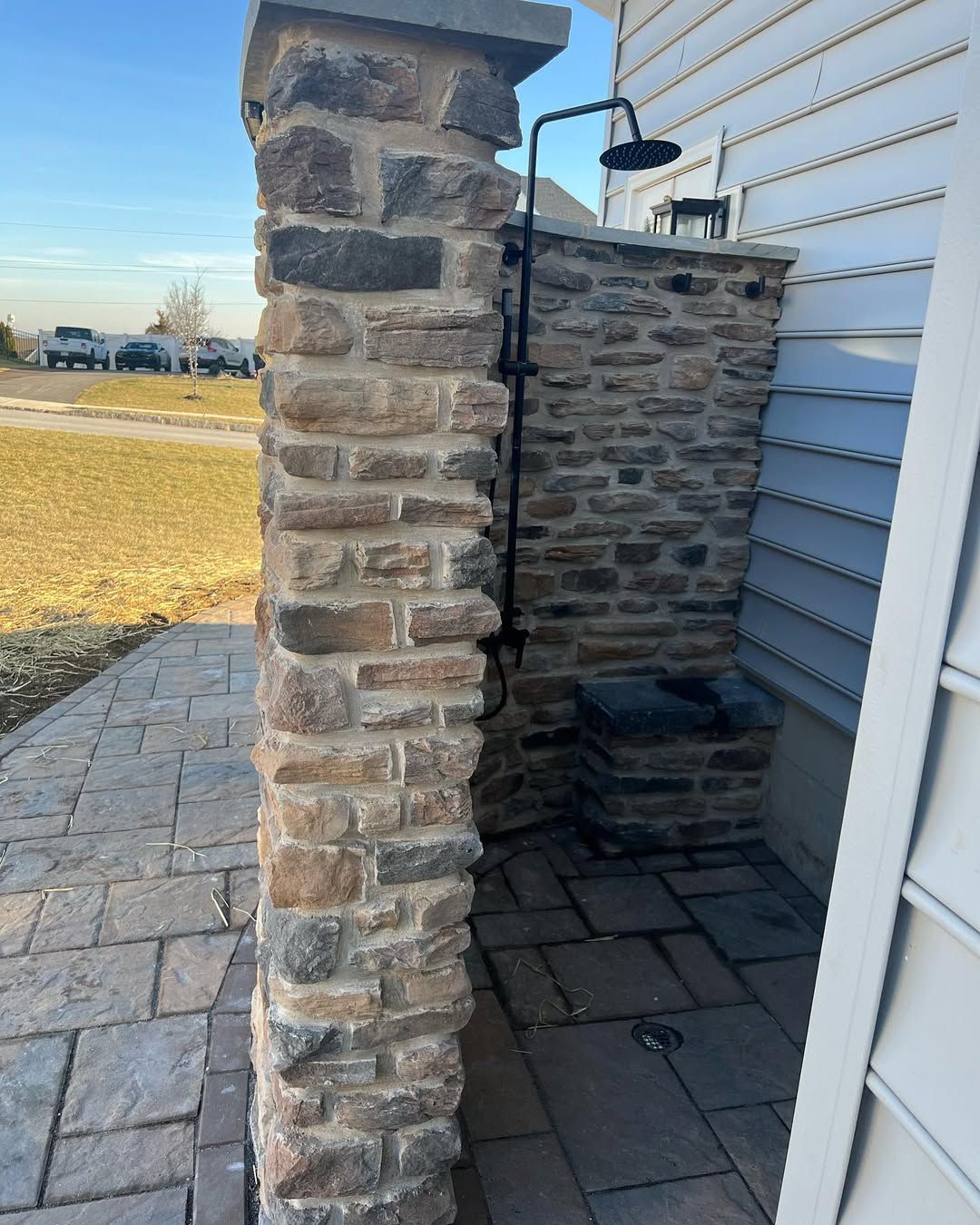A stone pillar with a shower head attached to it