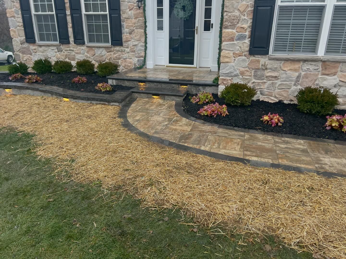 A stone house with a walkway leading to the front door.