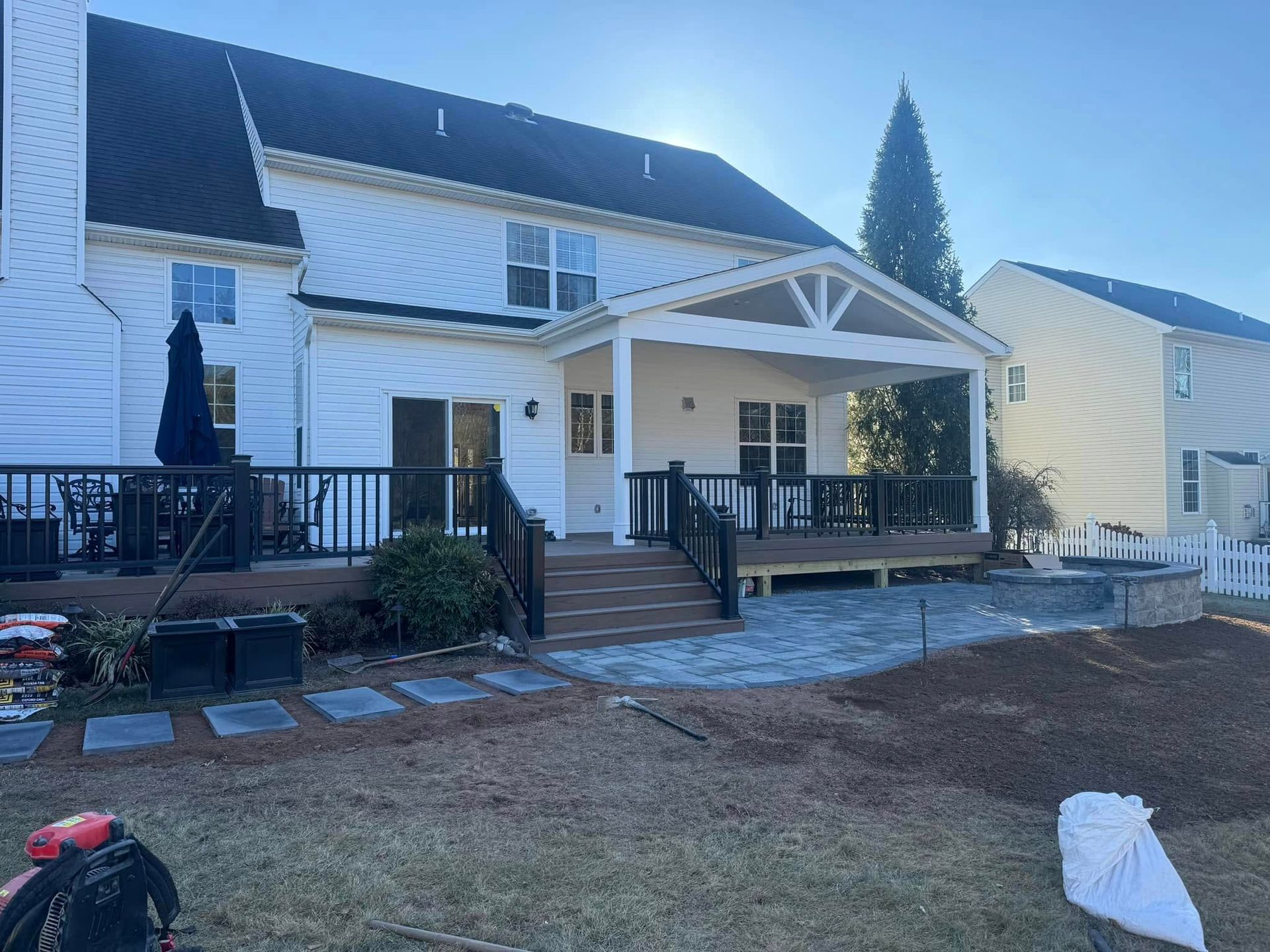 A large white house with a large deck and patio.