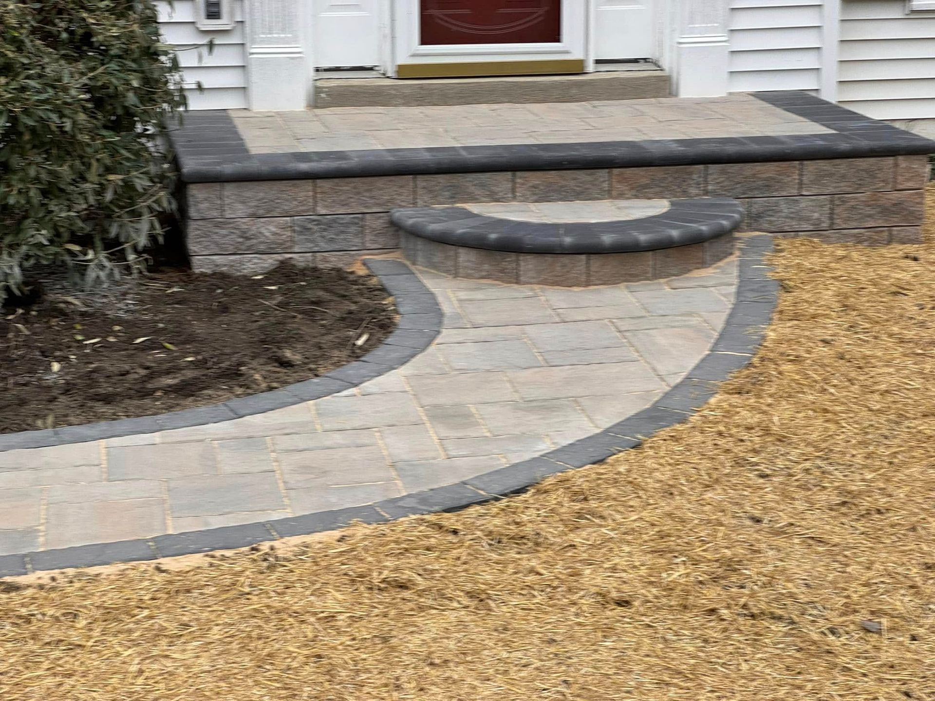 A brick walkway leading to the front door of a house.