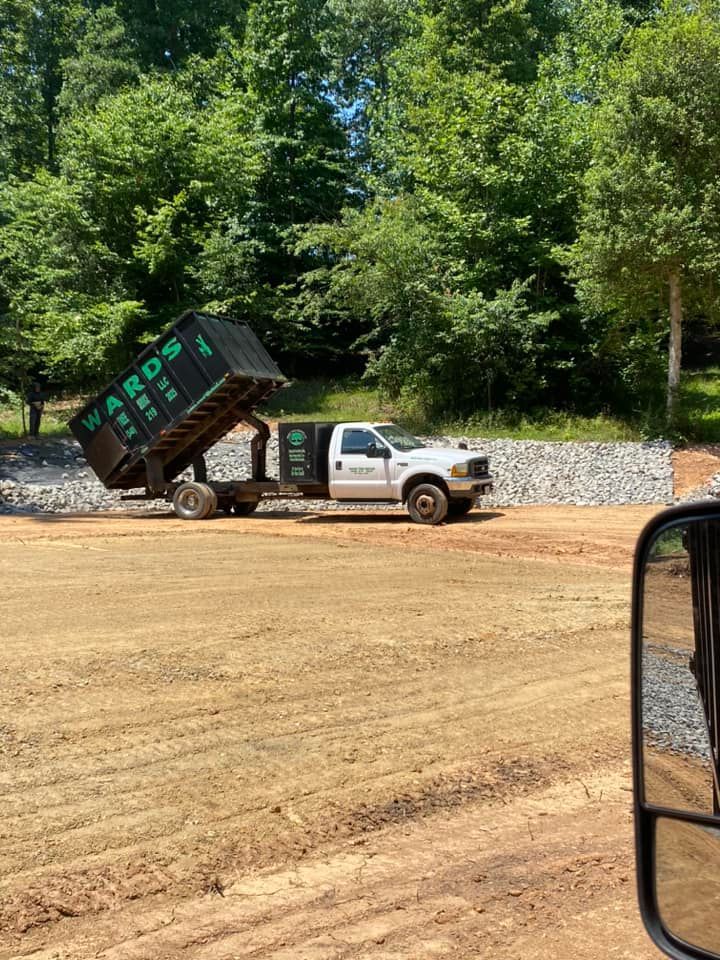 A white dump truck with a black container labeled
