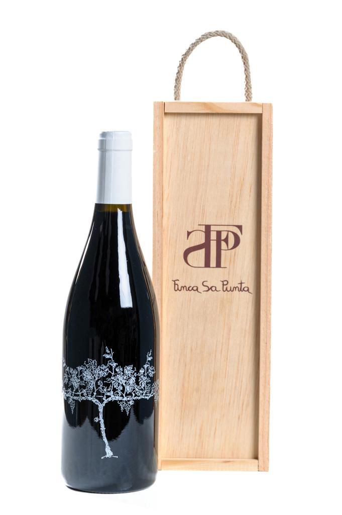 Una botella de vino está al lado de una caja de madera.