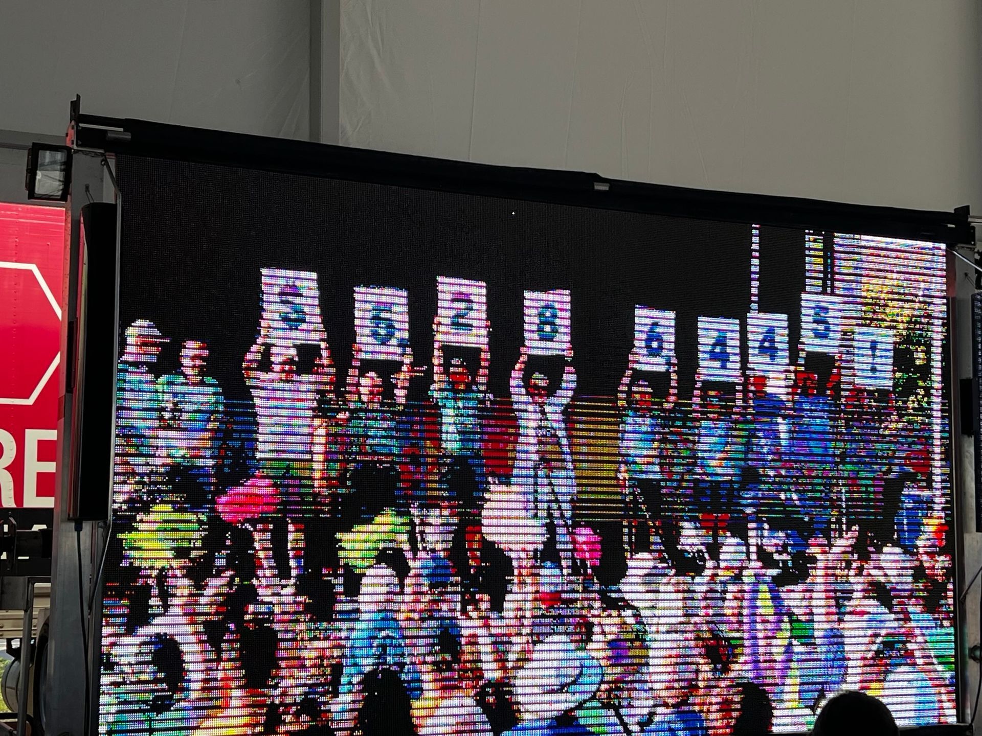 A Large Screen Shows a Crowd of People Holding Up Signs - Jamestown, NY - Colburns A/C & R, Inc.