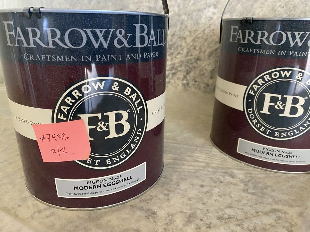Two maroon Farrow & Ball paint cans. One has a pink label with a number.