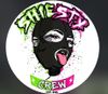 Graffiti-style circular logo with an illustrated black face, pink tongue out, and “SHE’S SEXY CREW” text.