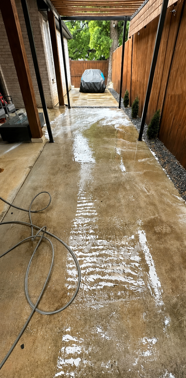 Flooded concrete corridor between brick walls, with standing water and a van visible at the end.