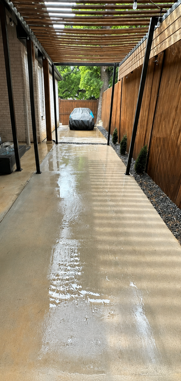 Flooded corridor with water covering the floor, leading to a parked car at the far end.