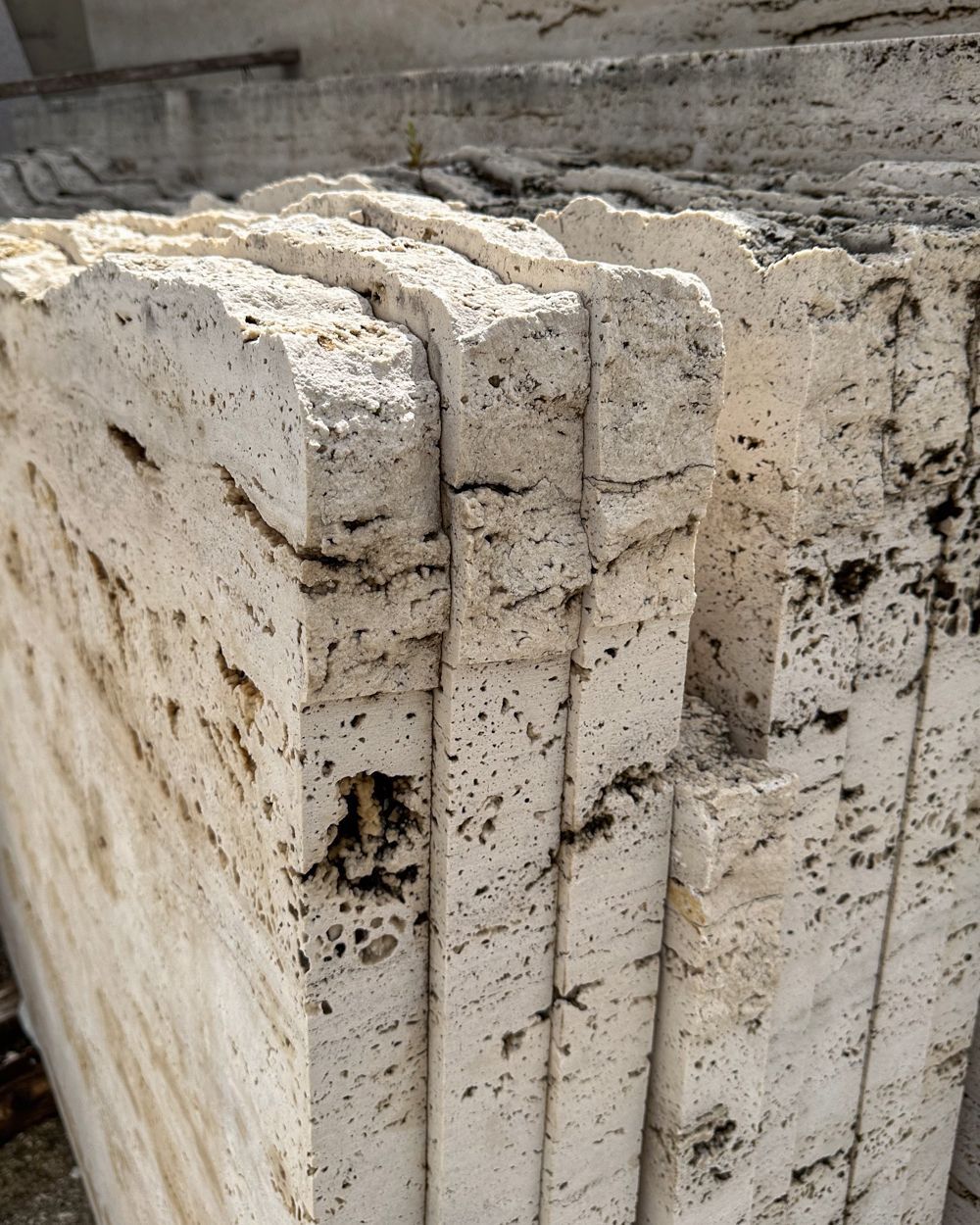 Camino angolare con marmo nero e venature dorate, posizionato su un pavimento in piastrelle beige e contro pareti bianche.