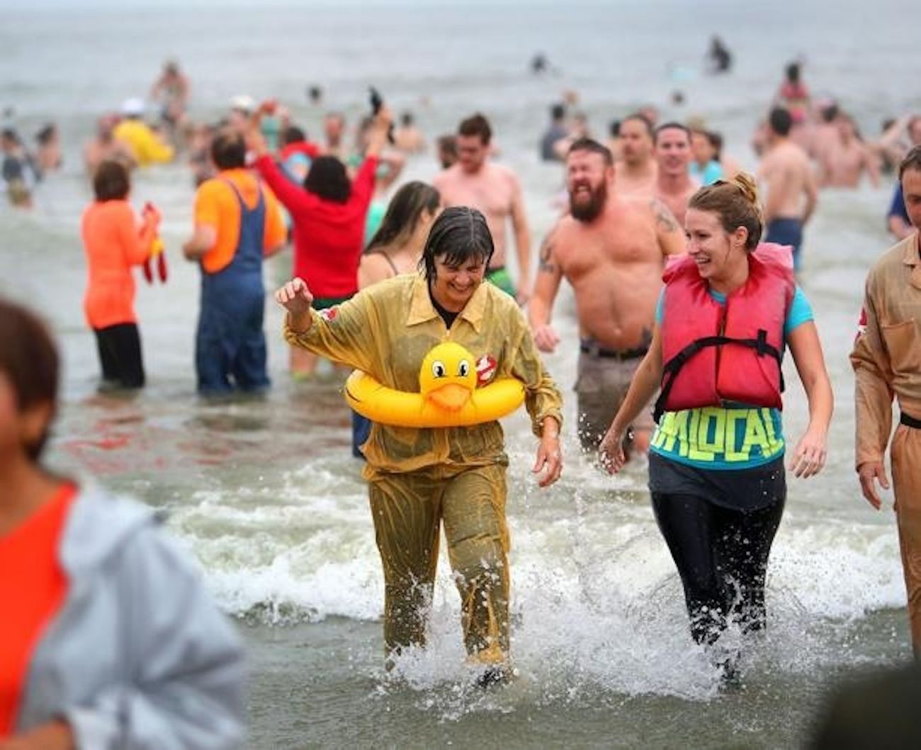 People wade in ocean water during a polar plunge event.