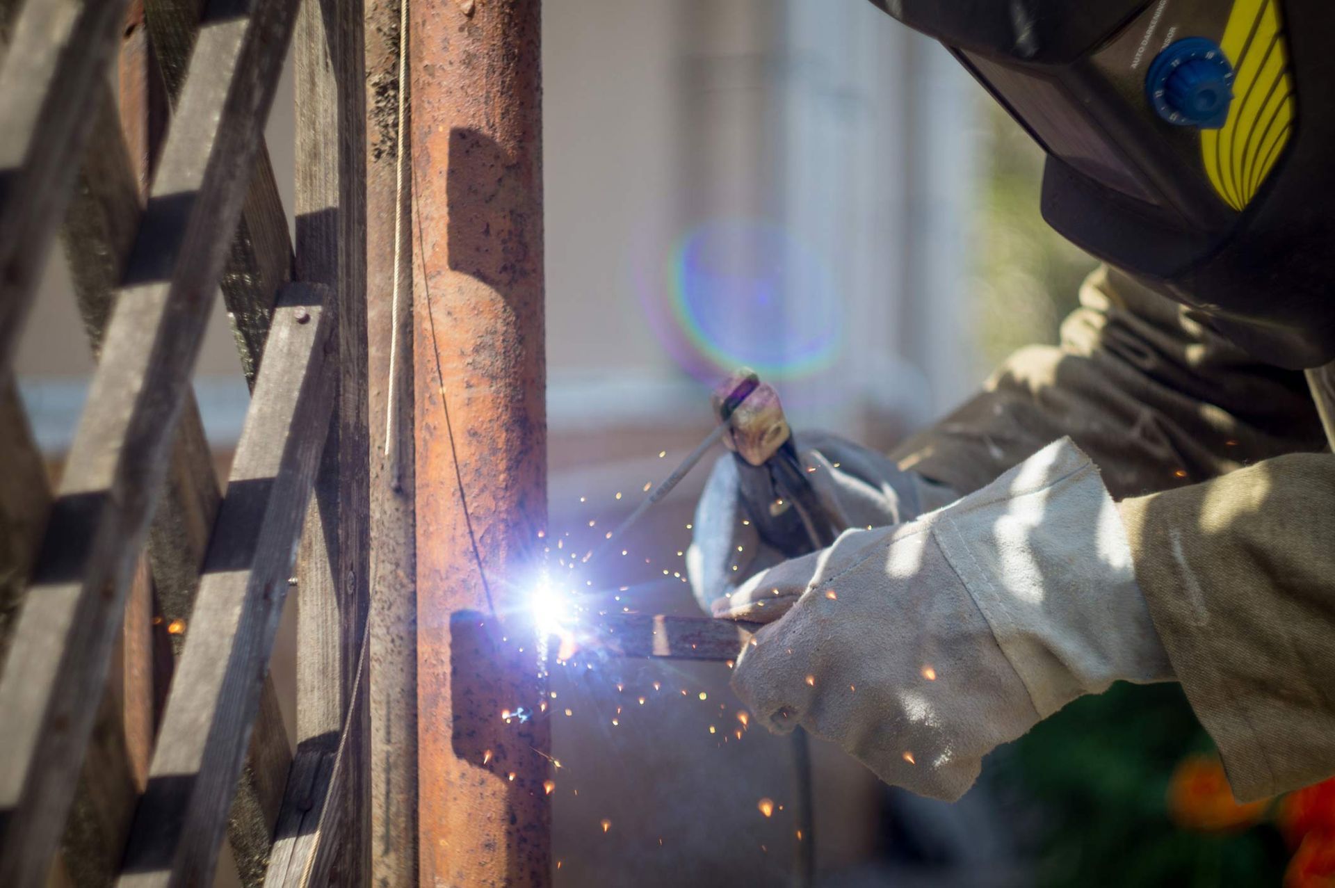 Close-up of welding torch in action with sparks flying, hands in protective gloves on metal surface. Close-up of welding torch in action with sparks flying, hands in protective gloves on metal surface.