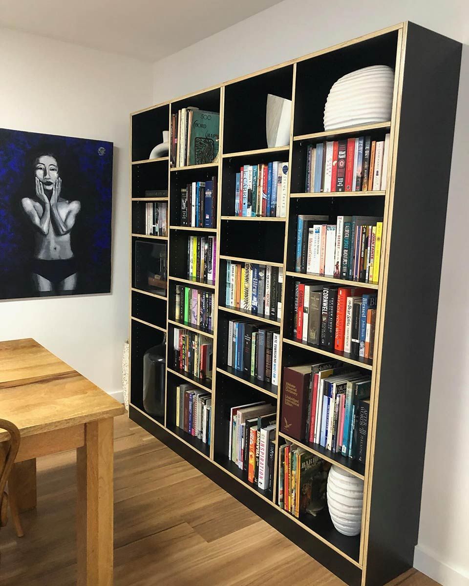 A Bookshelf With a Painting of a Woman Behind It — Coastal Detail Joinery in Tuncurry, NSW