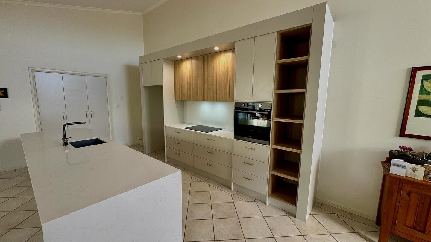 A kitchen with white cabinets and a large island in the middle of the room — Coastal Detail Joinery in Tuncurry, NSW