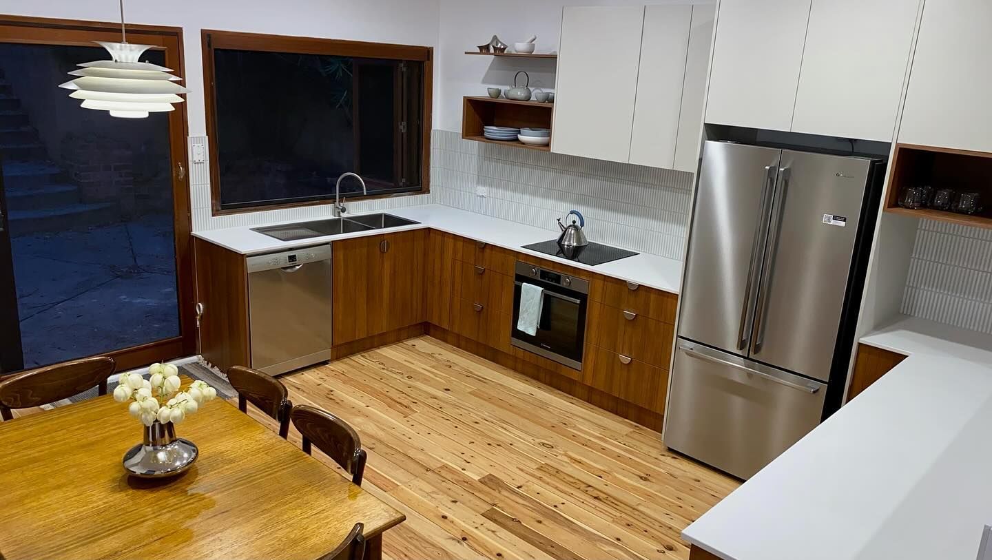 A kitchen with stainless steel appliances and wooden cabinets — Coastal Detail Joinery in Tuncurry, NSW