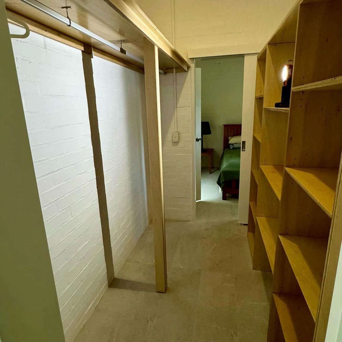 A Hallway With Shelves and a Door Leading to a Bedroom — Coastal Detail Joinery in Tuncurry, NSW