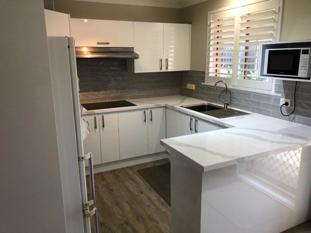 A Kitchen With White Cabinets, a Sink, a Refrigerator, and a Microwave — Coastal Detail Joinery in Taree, NSW