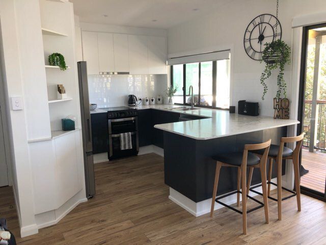 A Kitchen With Stools and a Clock on the Wall — Coastal Detail Joinery in Tuncurry, NSW
