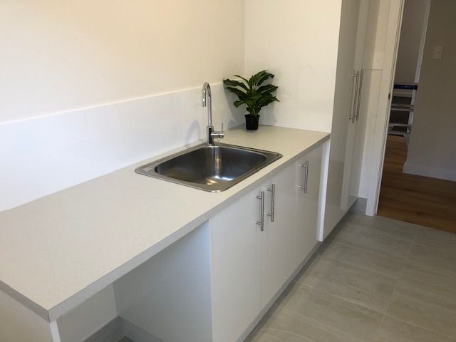 A Kitchen With a Sink and a Plant on the Counter — Coastal Detail Joinery in Harrington, NSW