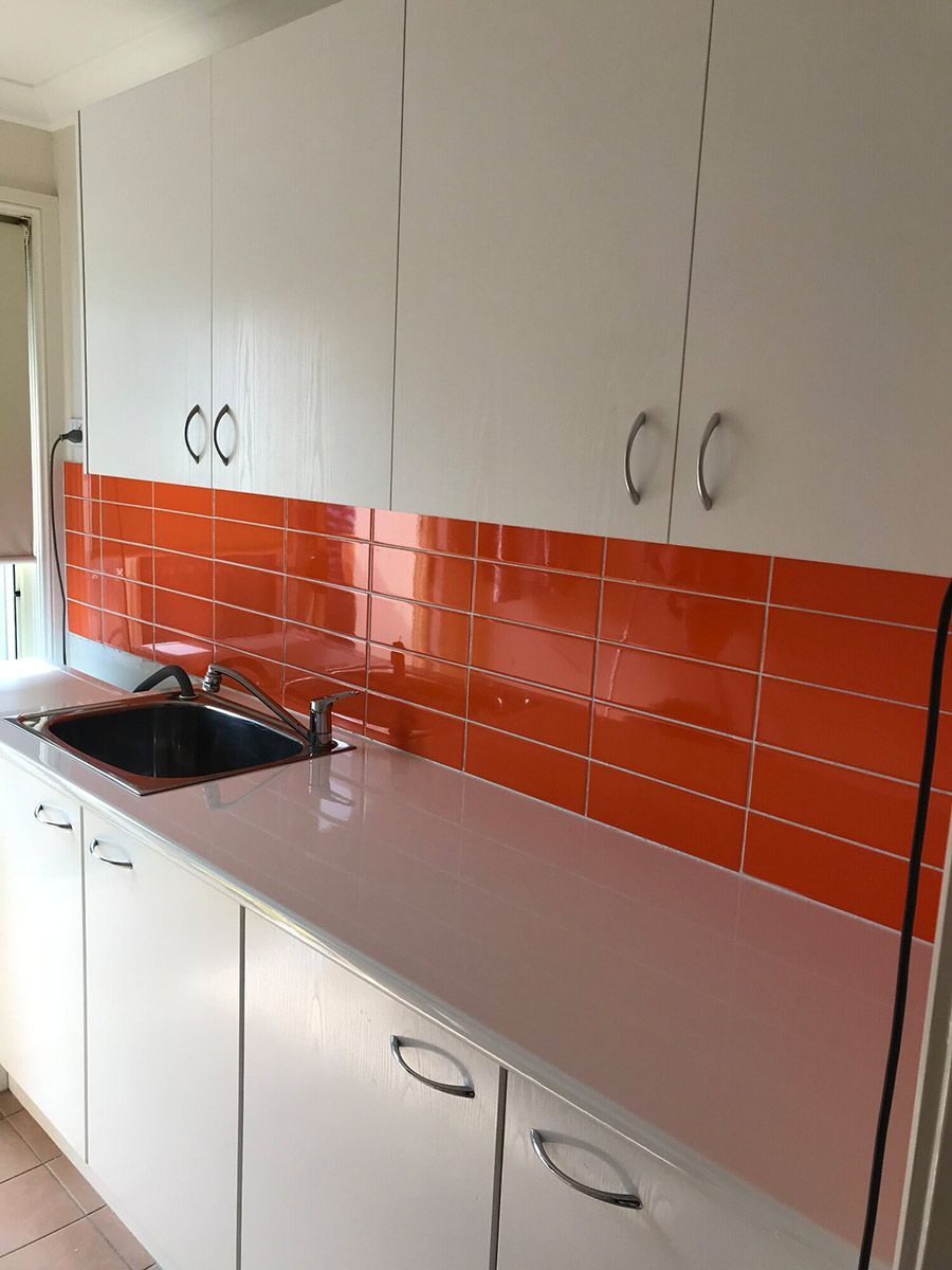 A Kitchen With White Cabinets and Orange Tiles — Coastal Detail Joinery in Tuncurry, NSW