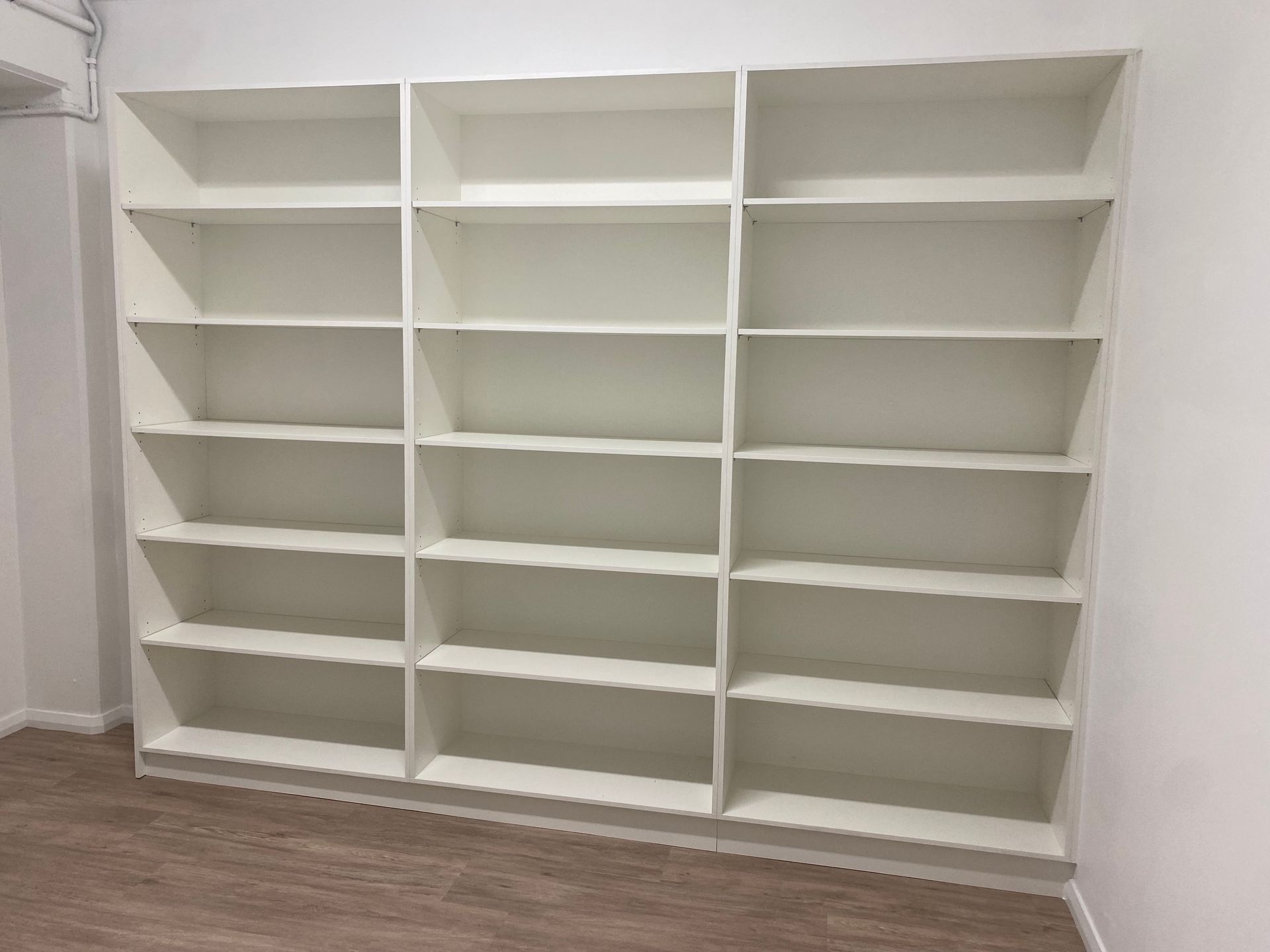 A room with a wall of shelves on a wooden floor — Coastal Detail Joinery in Tuncurry, NSW