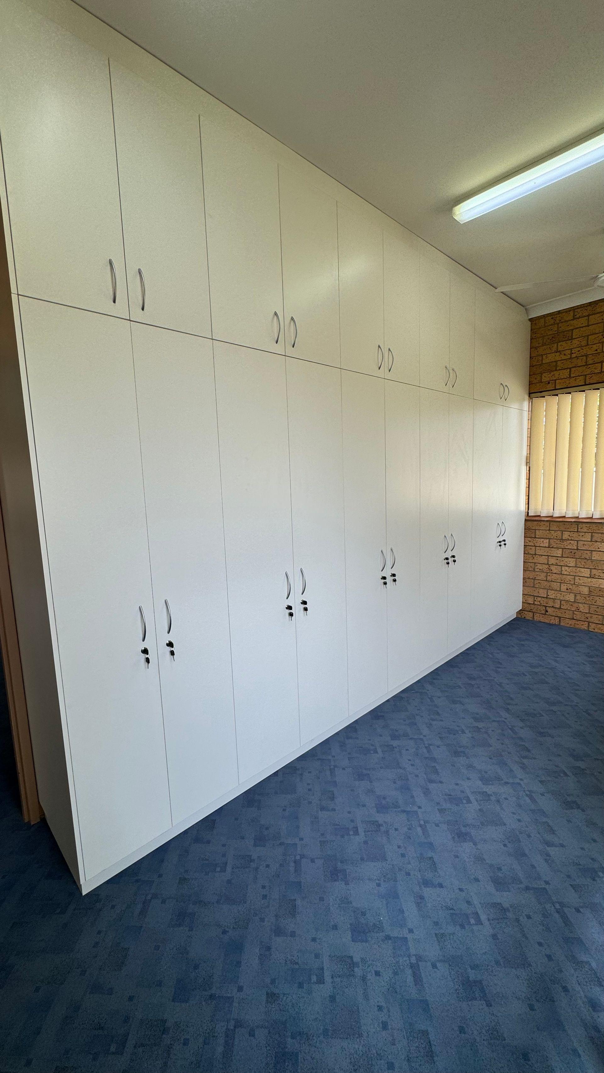 A room with white cupboards and blue carpet — Coastal Detail Joinery in Tuncurry, NSW