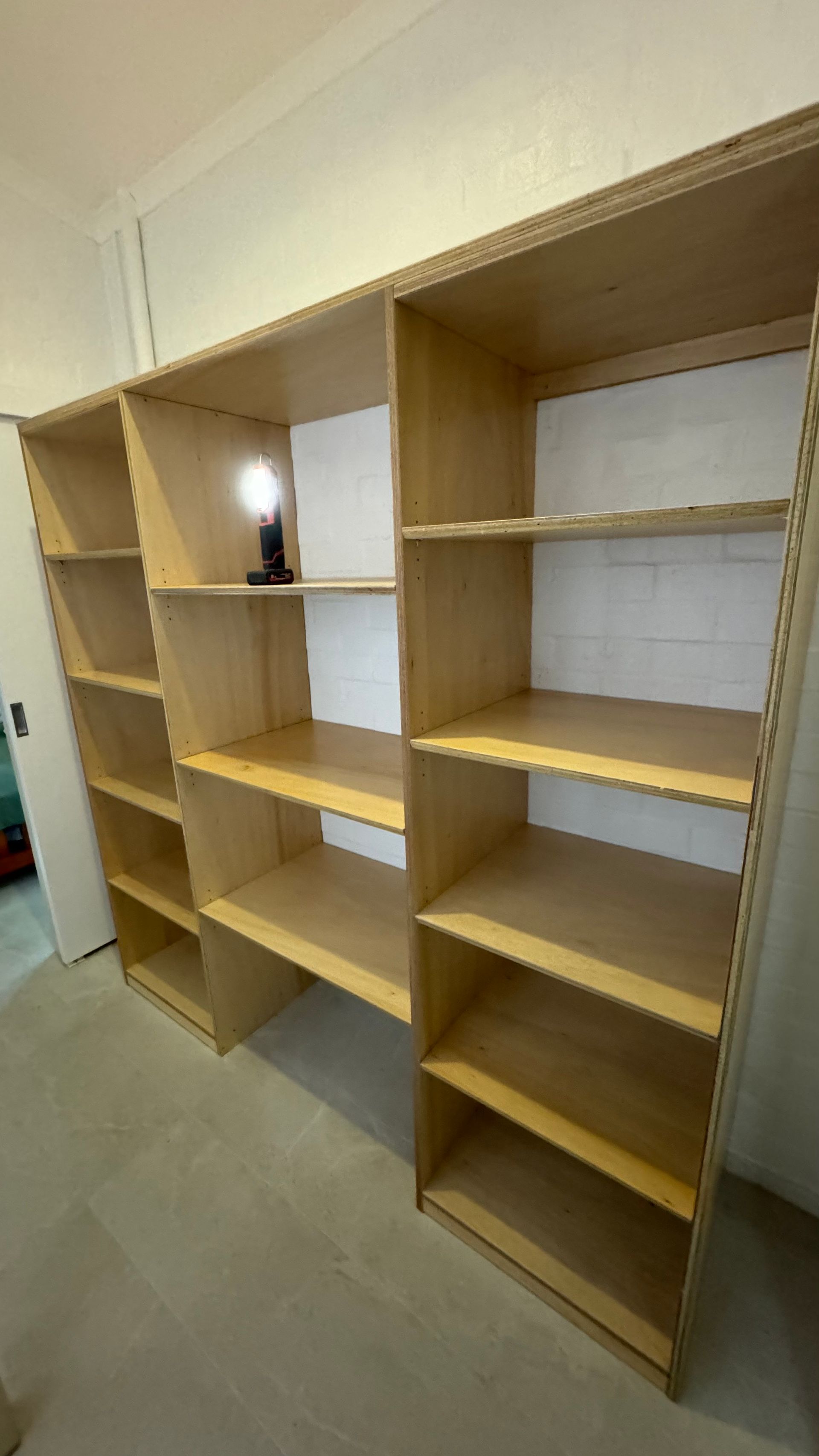 A row of wooden shelves in a room with a light on top of them — Coastal Detail Joinery in Tuncurry, NSW