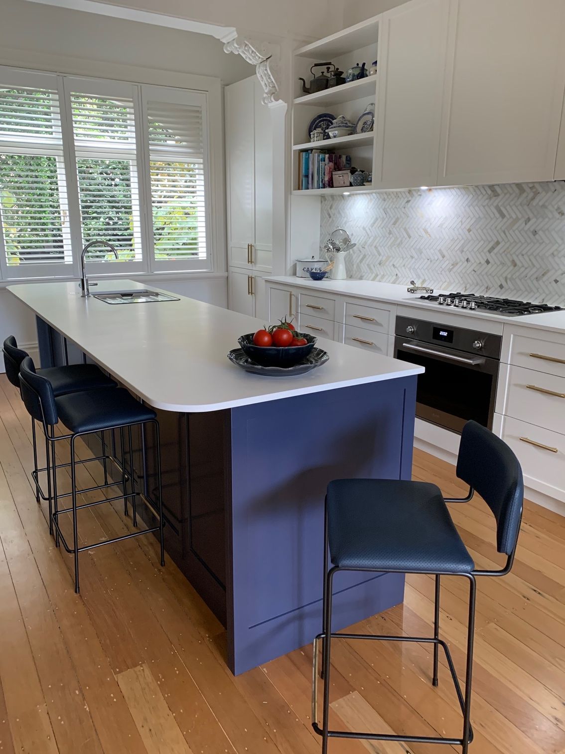 A kitchen with a large island and navy blue stools — Coastal Detail Joinery in Tuncurry, NSW