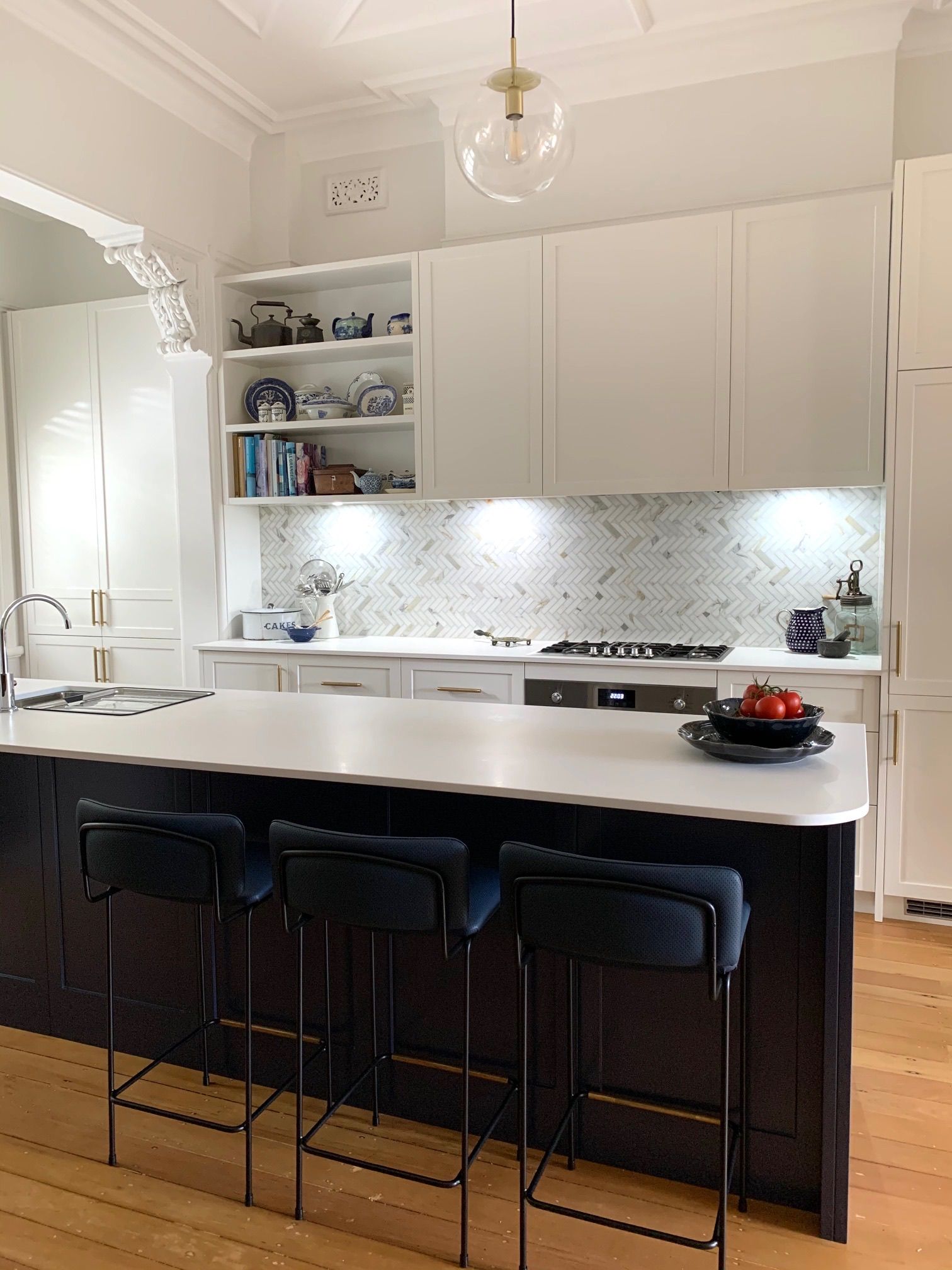 A modern kitchen with a large island and stools — Coastal Detail Joinery in Tuncurry, NSW