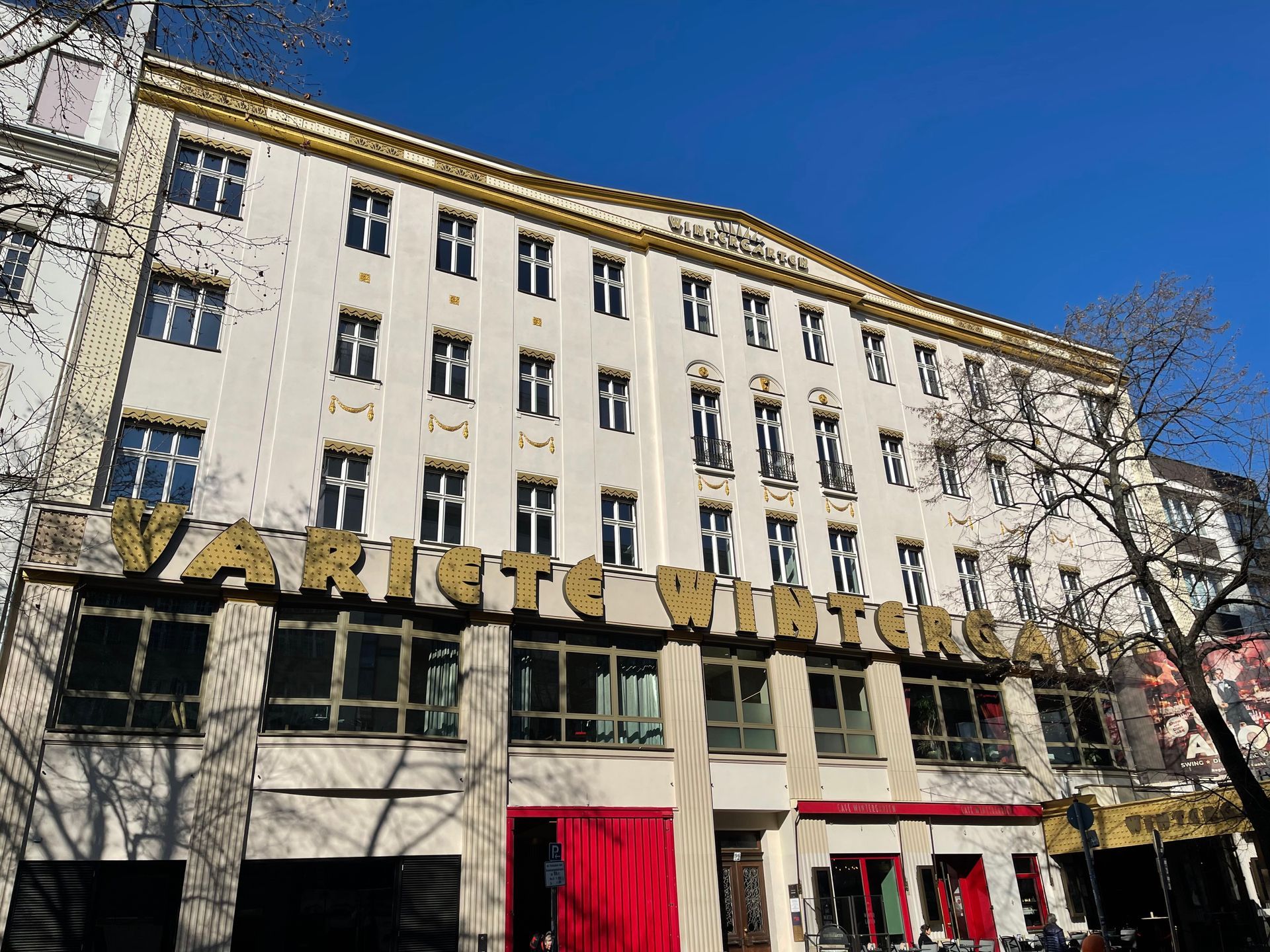 Weißes Haus mit braunem Dach und Fenstern vor klarem, blauem Himmel.