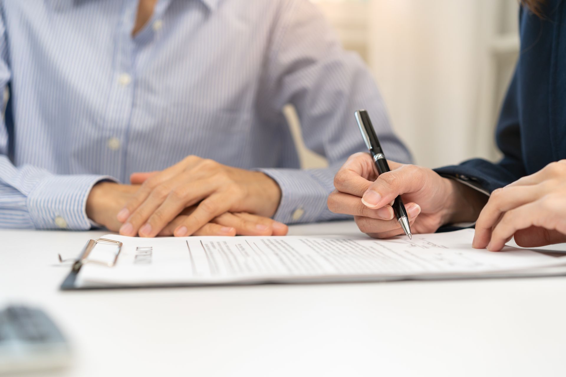 A man and a woman are sitting at a table signing a document.