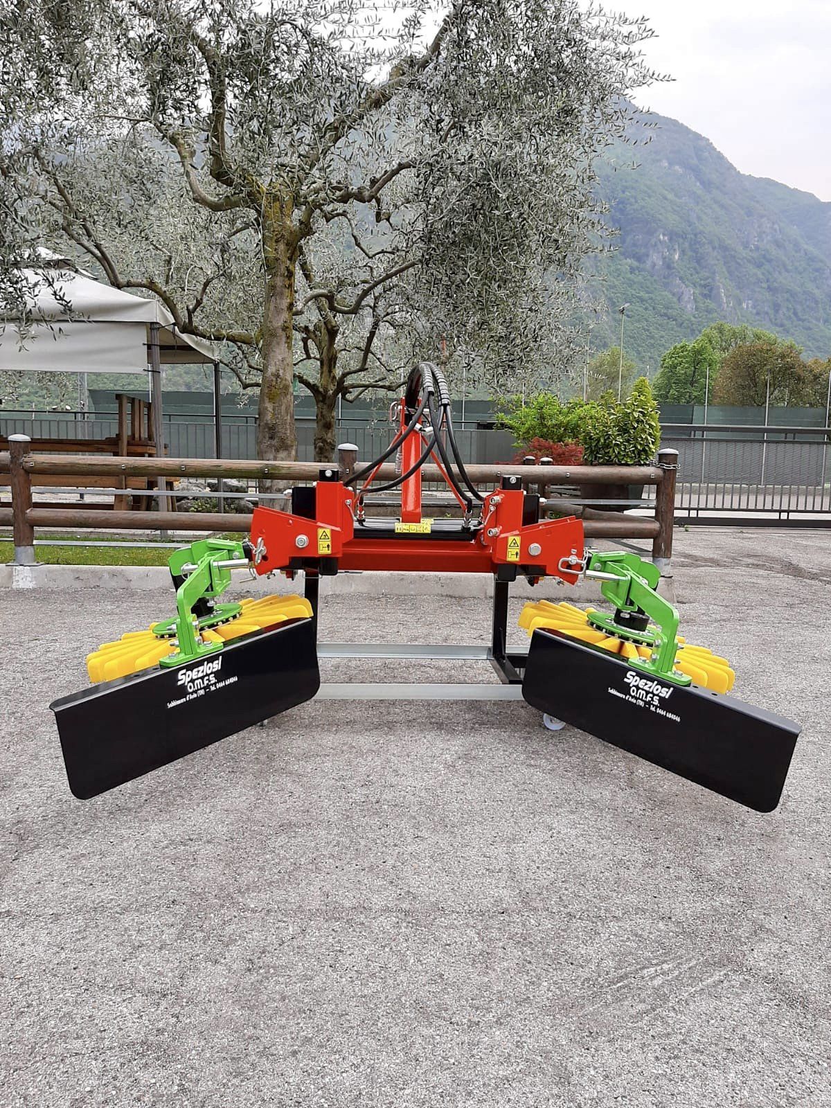 Una macchina rossa e verde è parcheggiata in cima a una strada sterrata.