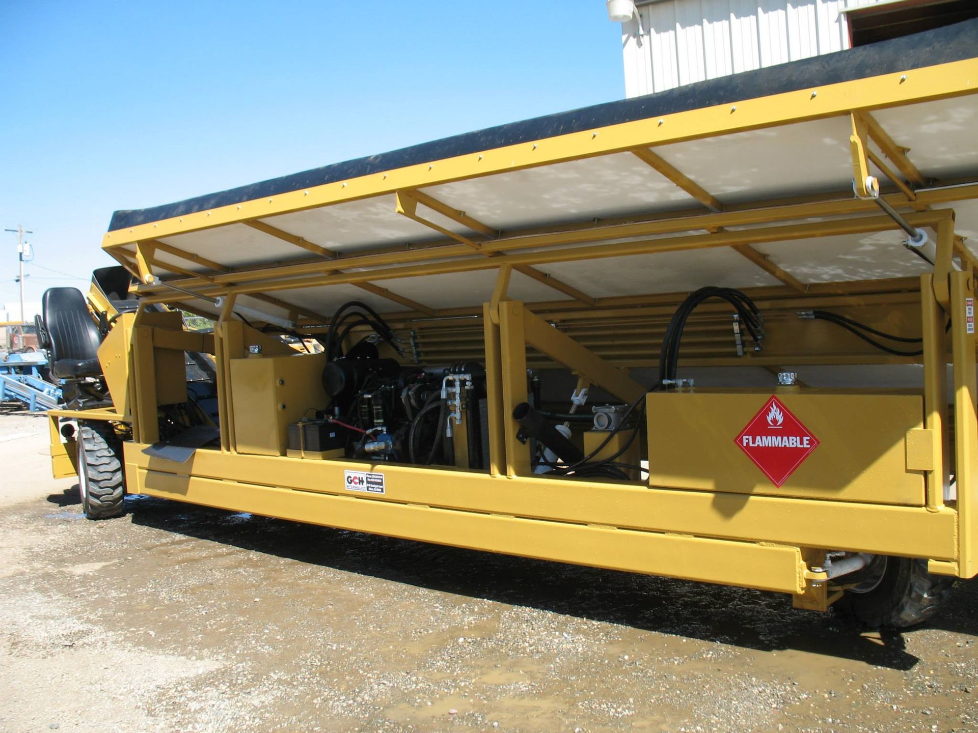 a yellow vehicle with a red flammable sign on the side