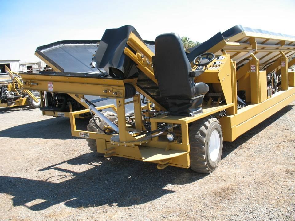 a yellow truck with black seats is parked in a gravel lot