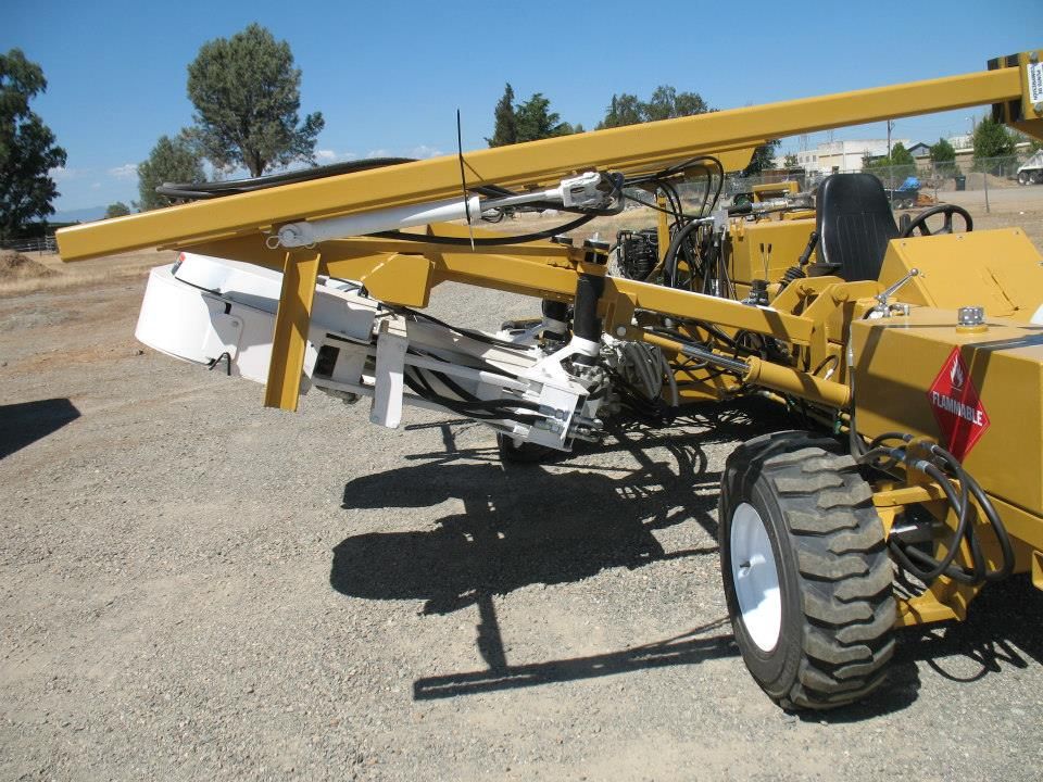 a yellow tractor is parked on a gravel road