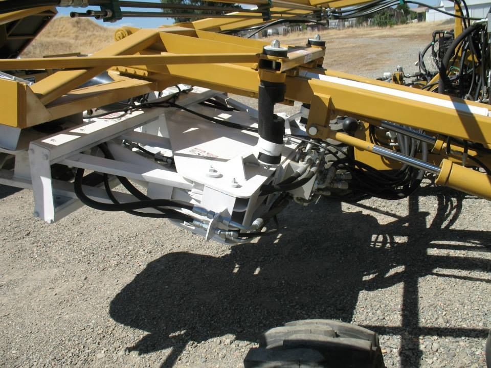 a yellow and white tractor is parked on a gravel road