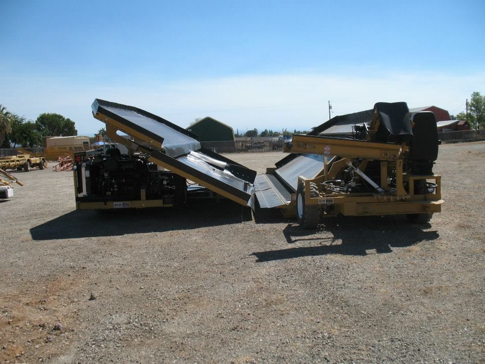 a yellow and black tractor is parked in a gravel lot