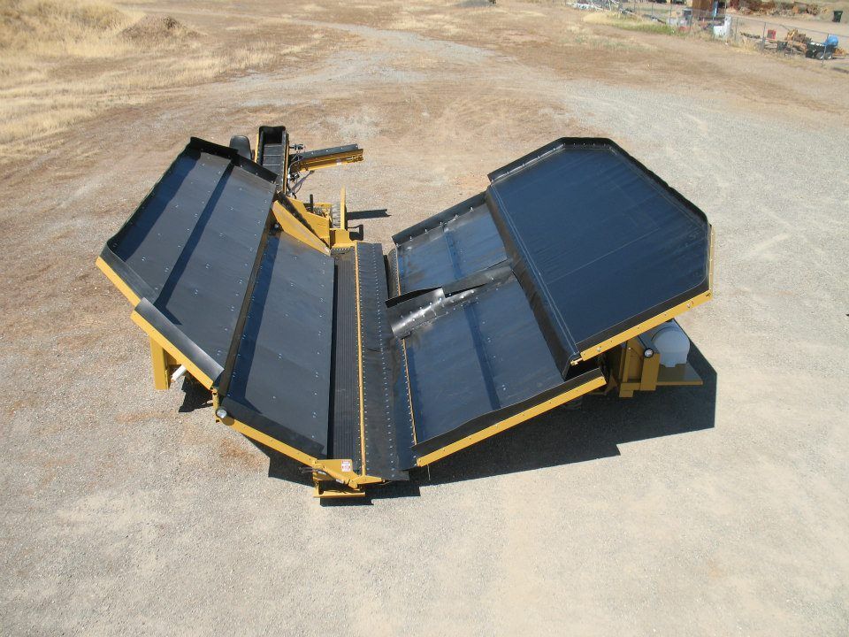 a harvester set is sitting on top of a dirt field .