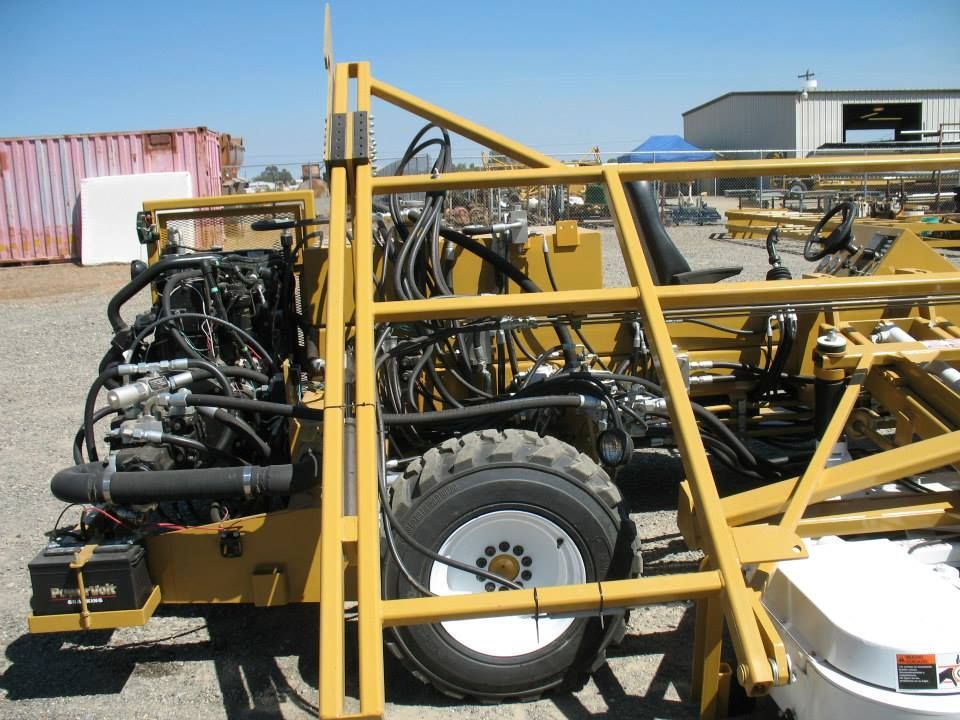 a yellow tractor is parked in a dirt field