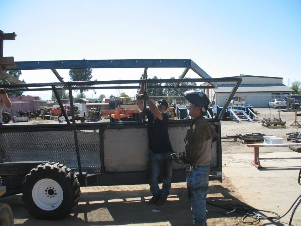 two men are working on a trailer in a parking lot