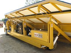 a yellow truck with the roof open is parked in a parking lot .
