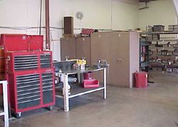 a workshop with a table , cabinets , and a red toolbox .