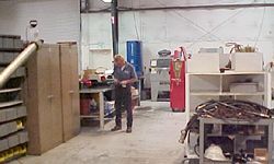 a man is standing in a warehouse looking at a piece of paper .