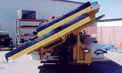a yellow and black machine is parked in front of a building .
